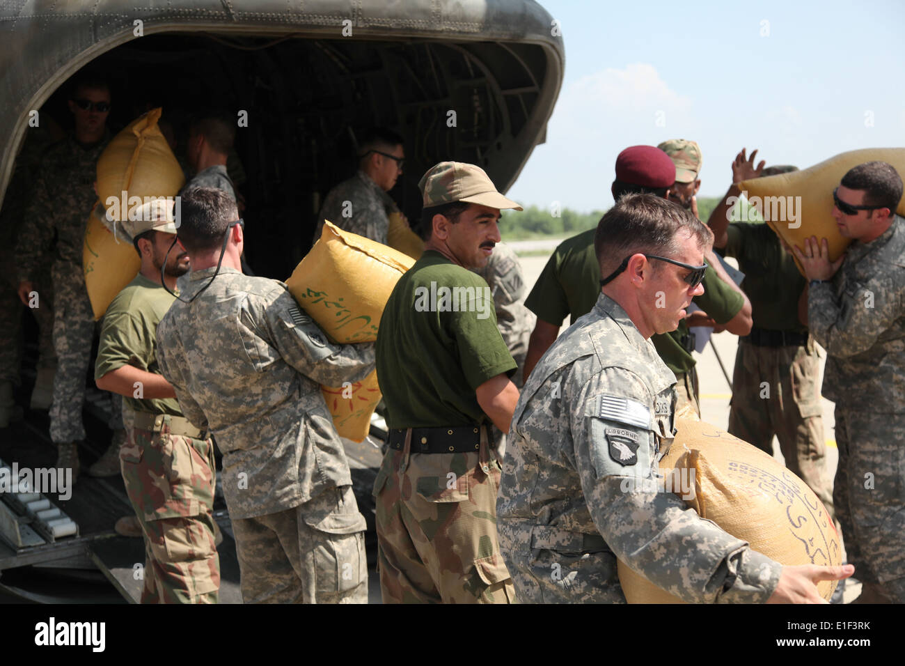 U.S. and Pakistani soldiers load bags of grain onto a U.S. Army CH-47 Chinook helicopter in Pakistan Aug. 5, 2010. Humanitarian Stock Photo