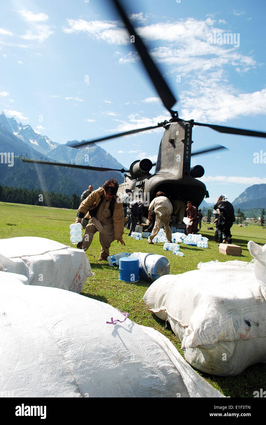 Pakistani men unload humanitarian relief supplies from a U.S. Army CH-47 Chinook helicopter in Kalam, Pakistan, Aug. 11, 2010. Stock Photo