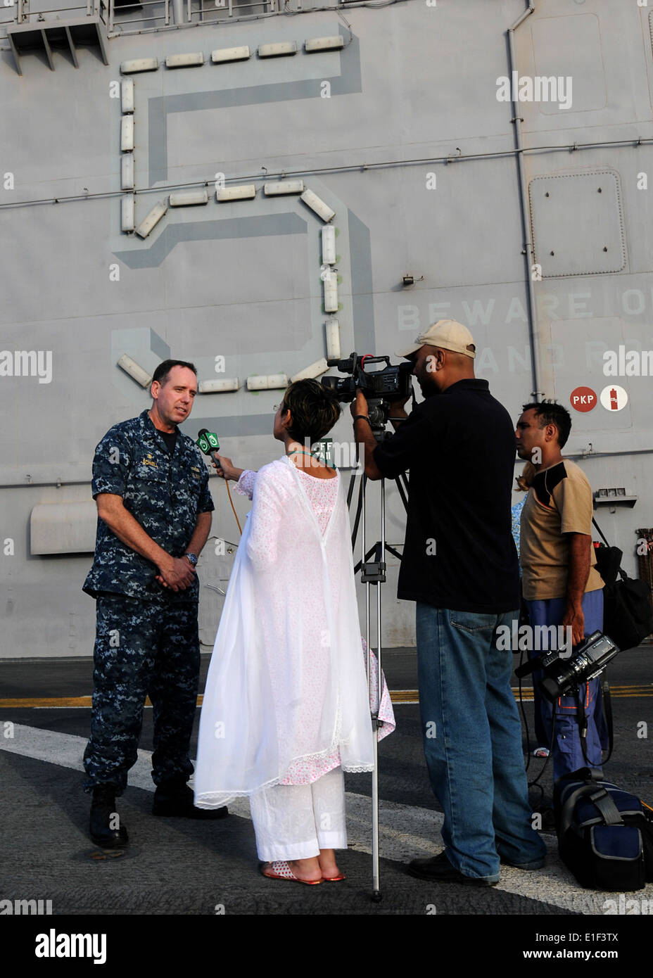 U.S. Navy Capt. David Schnell, left, commanding officer of USS Peleliu (LHA 5), is interviewed on the Peleliu flight deck durin Stock Photo