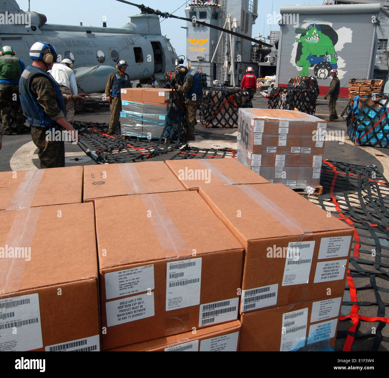 Personnel assigned to the amphibious transport dock ship USS Dubuque (LPD 8) Combat Cargo Platoon wrap a pallet of humanitarian Stock Photo