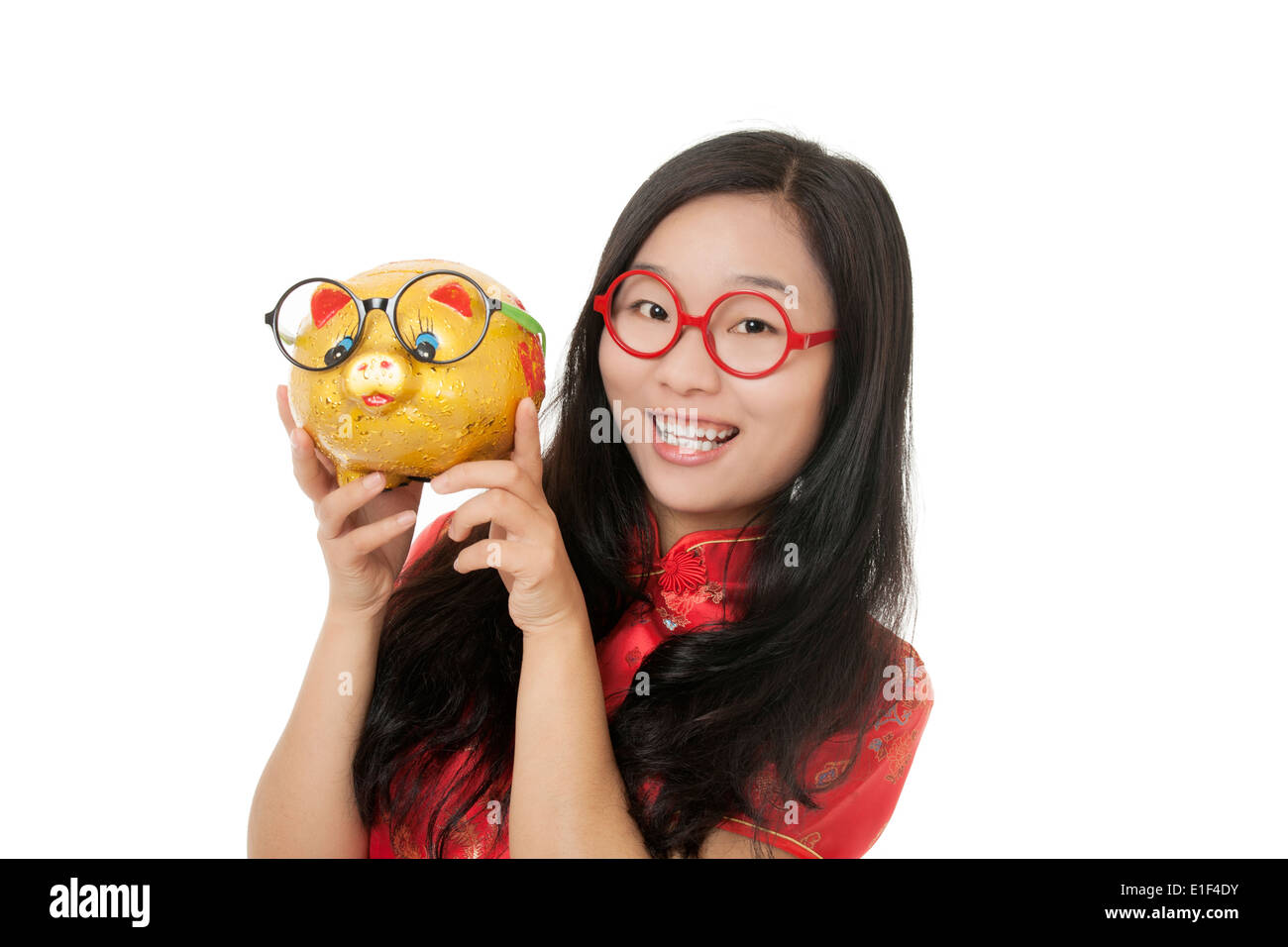 Beautiful Chinese woman wearing a traditional dress known as a Chipao holding a piggy bank Stock Photo