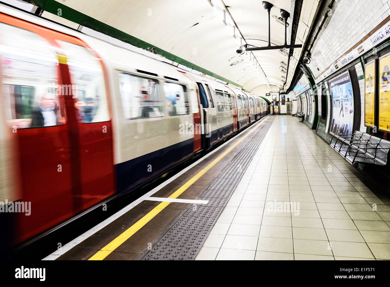 A London Underground Tube train leaving a station. Stock Photo