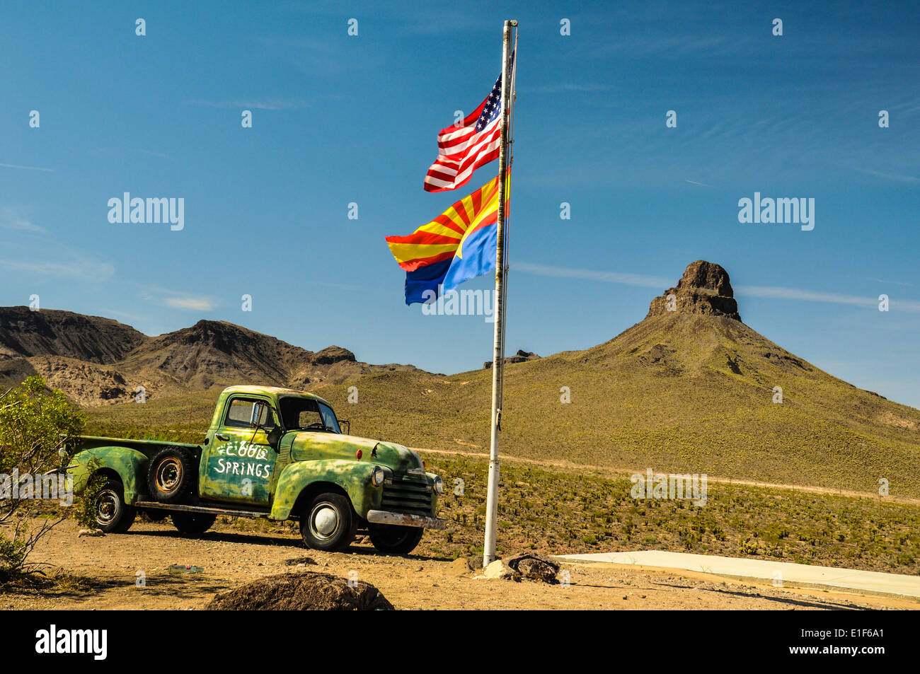 Vintage car on Route 66 in the Mojave desert with national and state flags Stock Photo