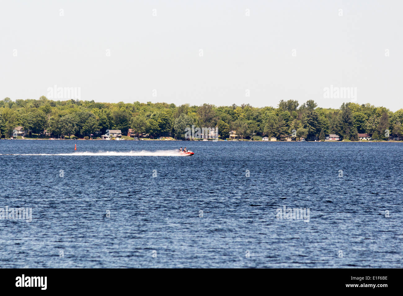 View of Cameron lake where you can see two men going fast on a Sea-doo personal watercraft Stock Photo
