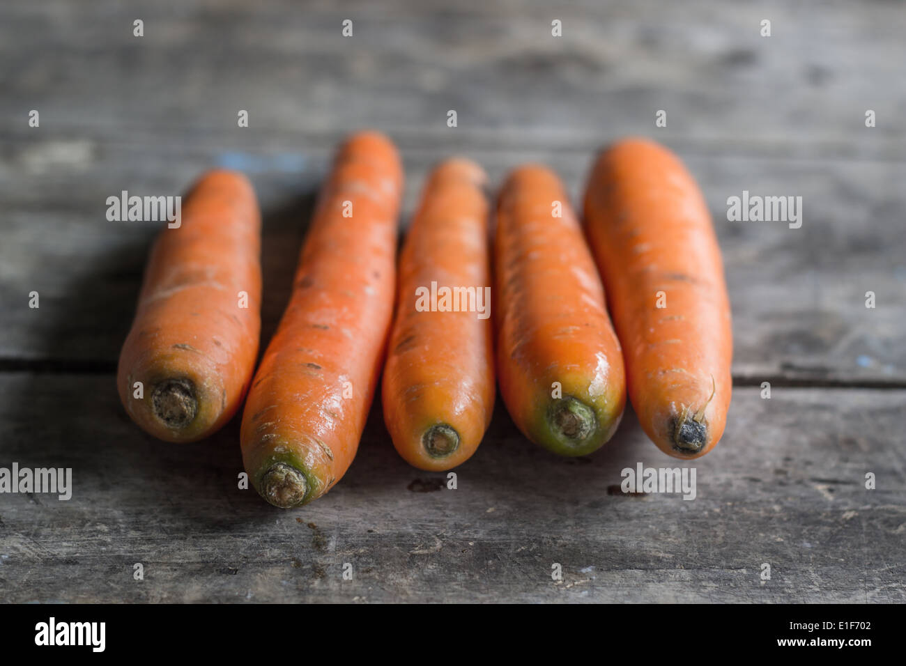 fresh organic carrots on wooden table, natural light Stock Photo