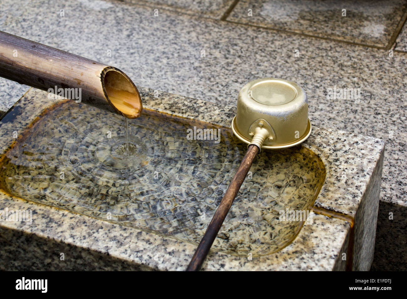 Stone wash basin with scoop at buddhist temple Stock Photo - Alamy