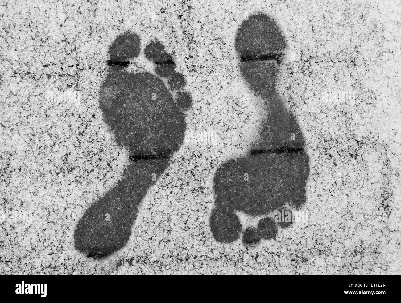 Two opposite barefoot footprints on snow at winter Stock Photo