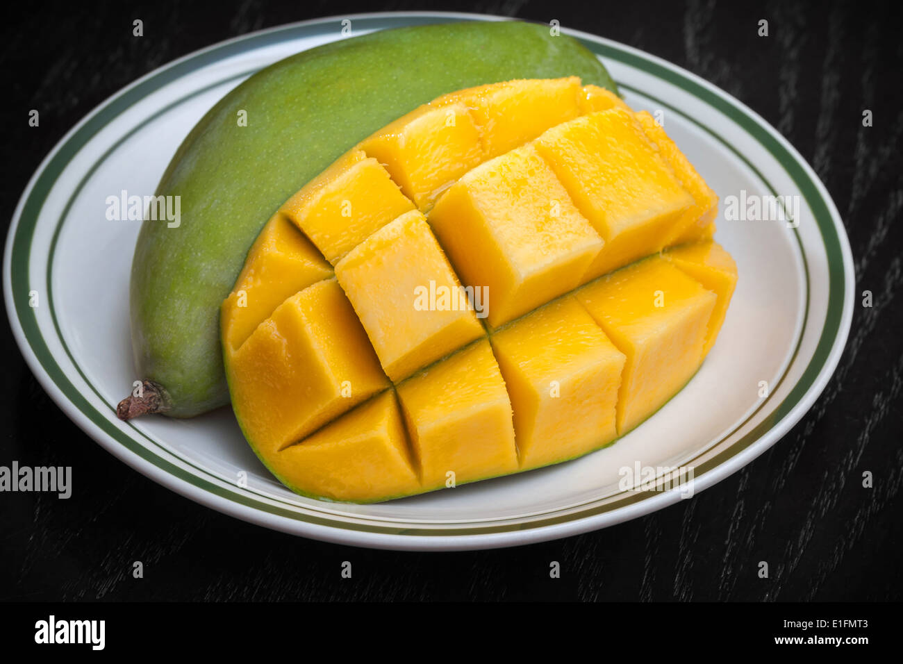 Yellow sliced on cubes mango on white plate Stock Photo