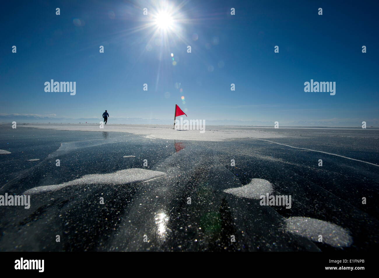 Runner in the 10th Baikal Ice Marathon, run on the frozen surface of the world's largest lake, Siberia, Irkutsk Oblast, Russia Stock Photo