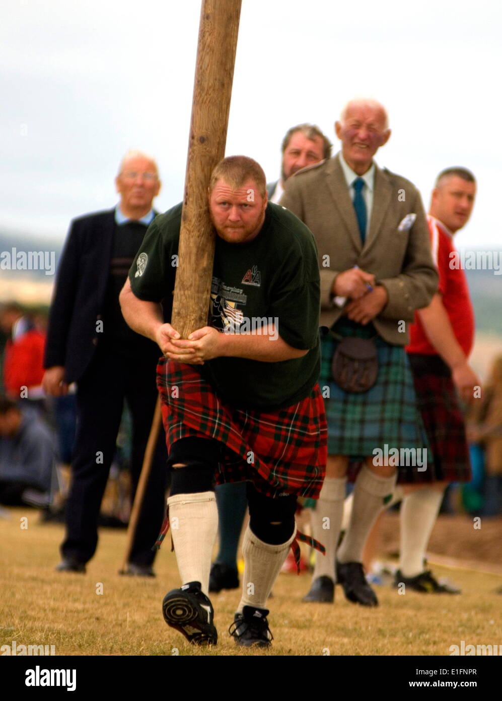 Tossing the caber at Montrose Highland Games, watched by Judge Sandy Gray in kilt, Montrose, Angus, Scotland, United Kingdom Stock Photo