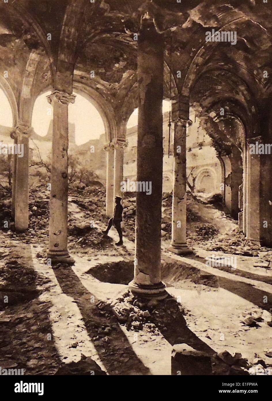 Photograph taken in the aftermath of Bombings during World War I.  A soldier stands within ruins of the Cloister of the Cathedral in Arras, France. Dated 1919 Stock Photo