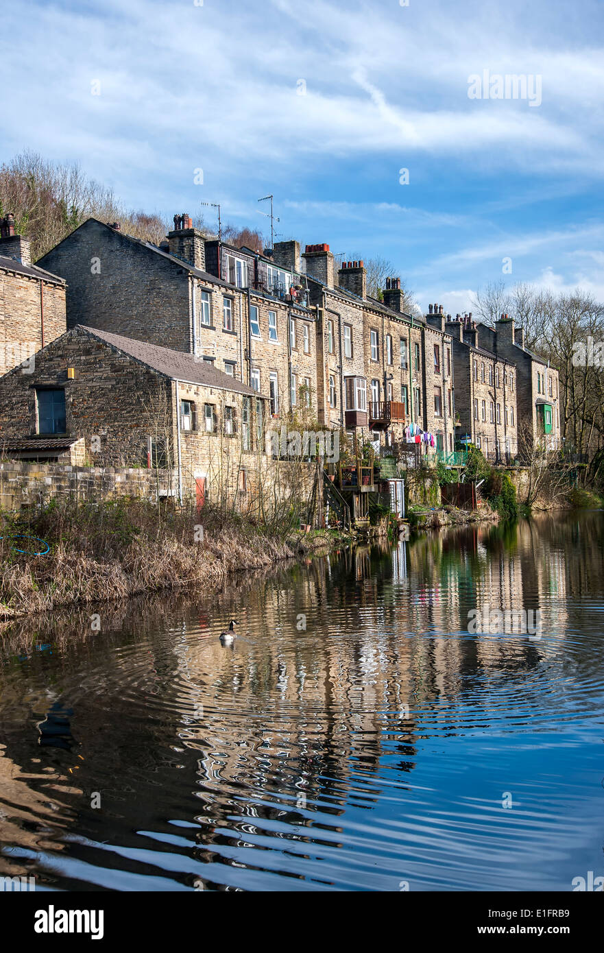 Tall back to back terraced houses on the banks of a canal in Yorkshire. Stock Photo