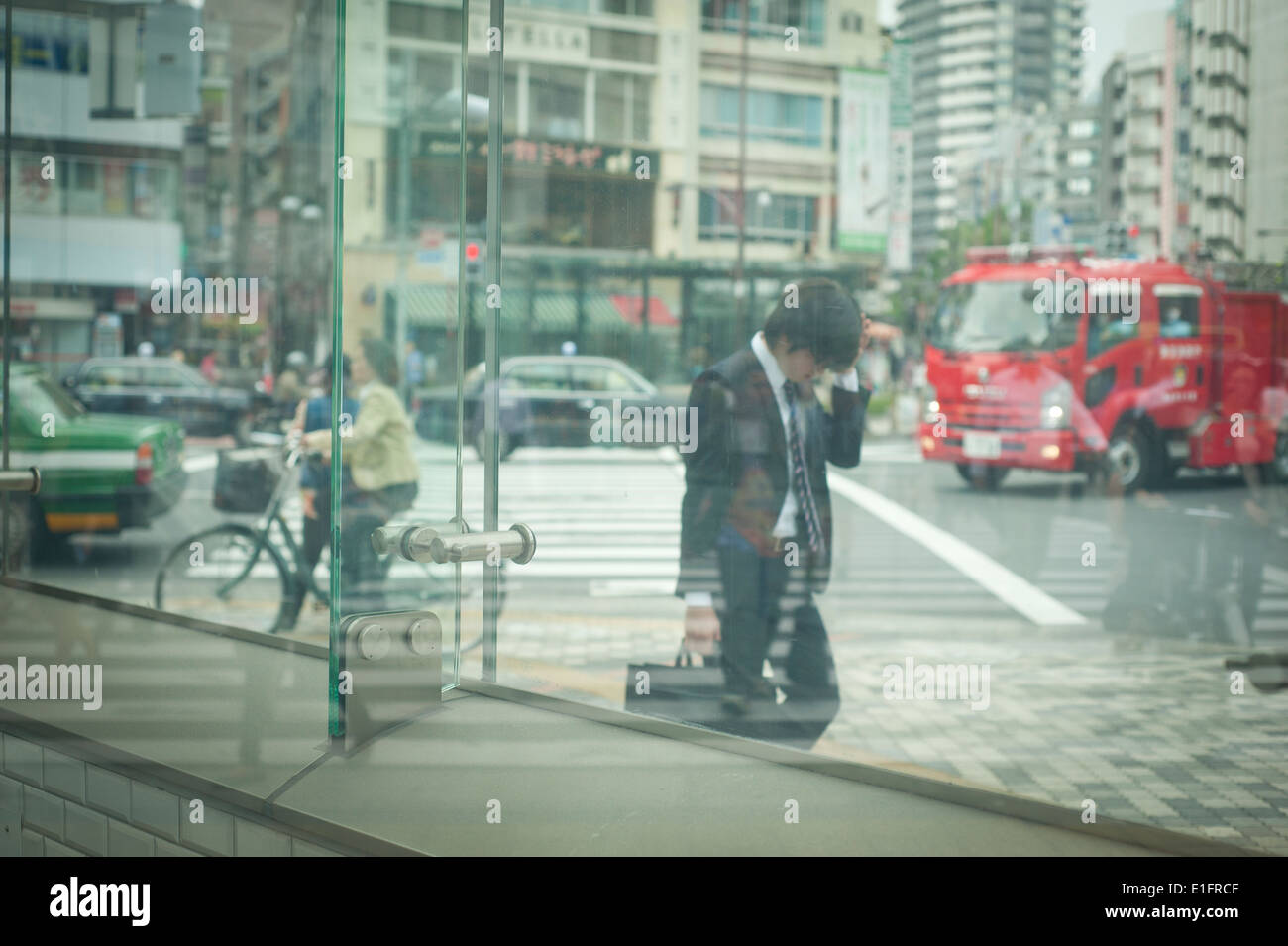 Tokyo, Japan - Street scene business men talking on phone through glasses Stock Photo