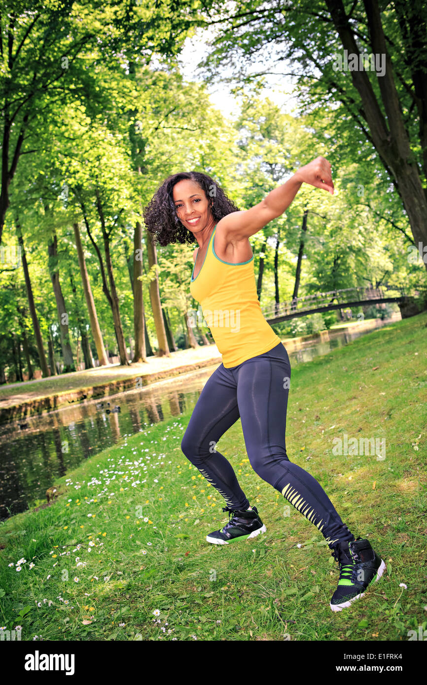 woman dancing the new fitness dance called zumba or aerobics in an old park Stock Photo