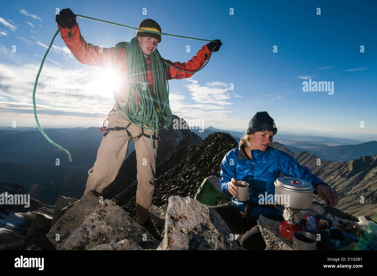 Alpine In Ridge Line A man and a woman boiling water on campstove on rocky, alpine ridgeline ...