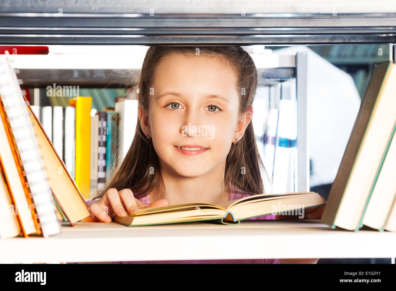 Girl with open book portrait through bookshelf Stock Photo Alamy
