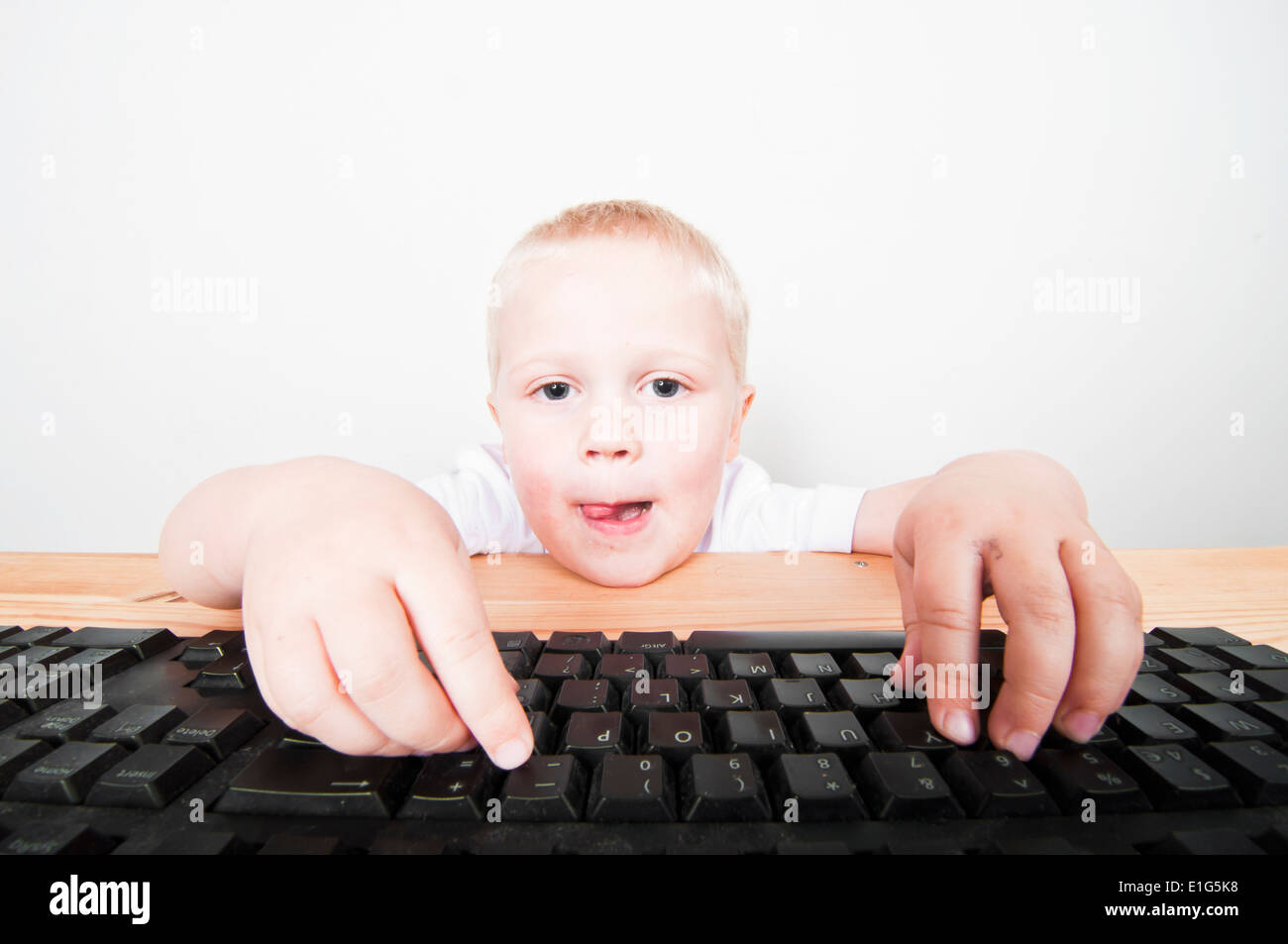 Little boy isolated against white using a laptop computer Stock Photo