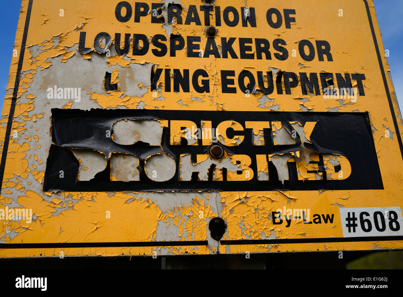 Flaking paint on old sign prohibiting noise from loudspeakers or amplifying equipment in a Toronto Park Stock Photo