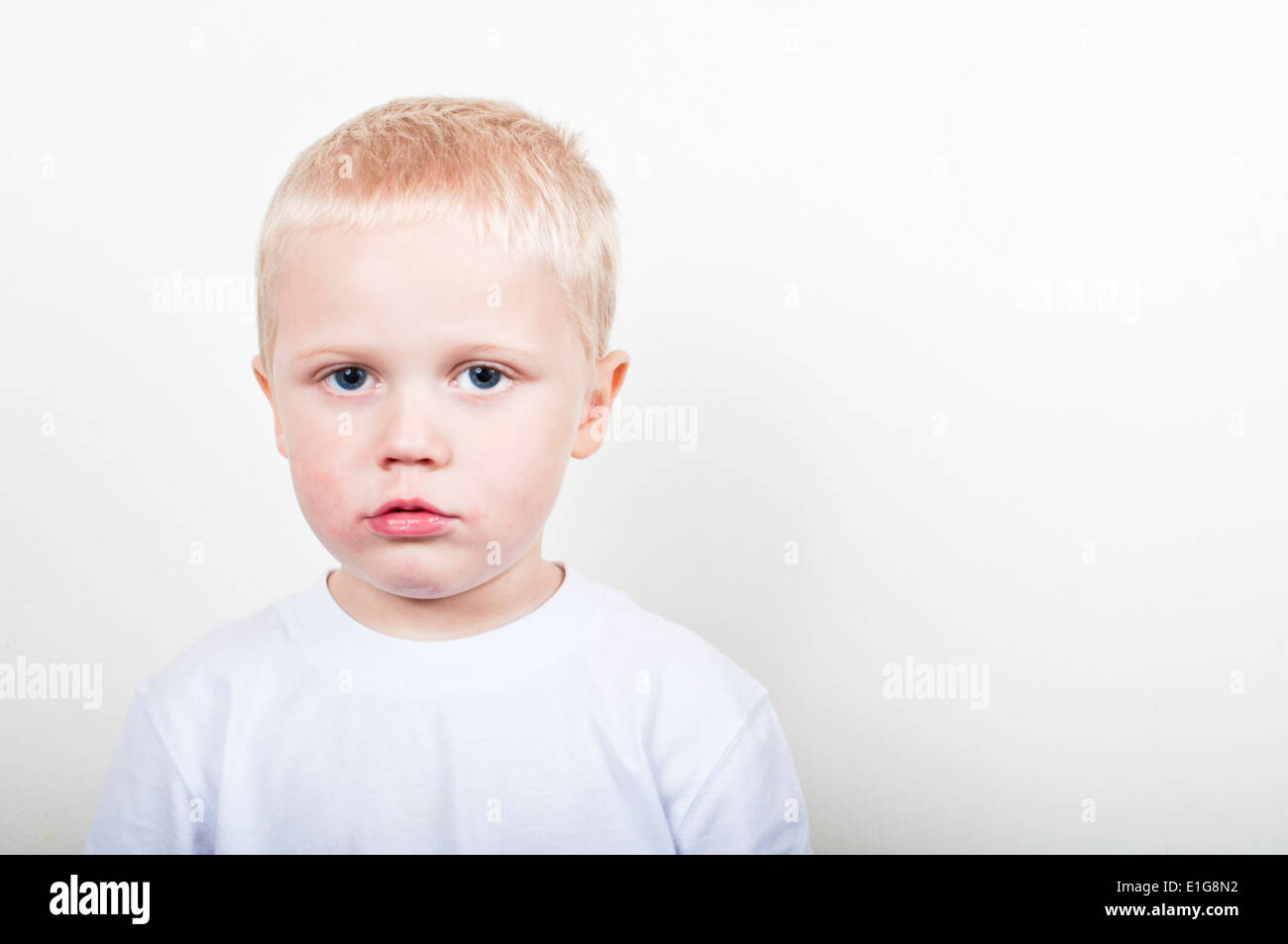Sad faced little boy with an unhappy expression Stock Photo