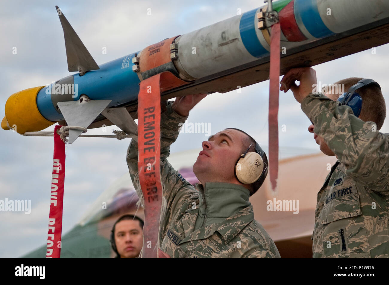 U.S. Air Force Senior Airman Benjamin Whitfield, center, and Airman 1st Class Karl Nielson, aircraft armament systems weapons l Stock Photo