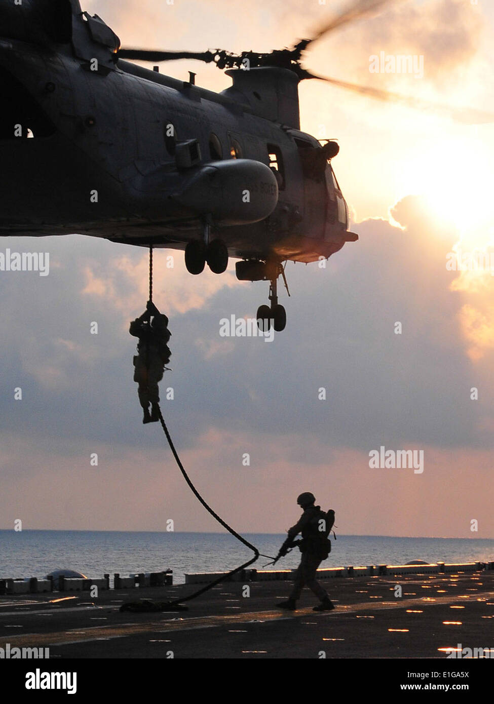 U.S. Marines assigned to the 13th Marine Expeditionary Unit (MEU) drop from a CH-46 Sea Knight helicopter assigned to Marine Me Stock Photo