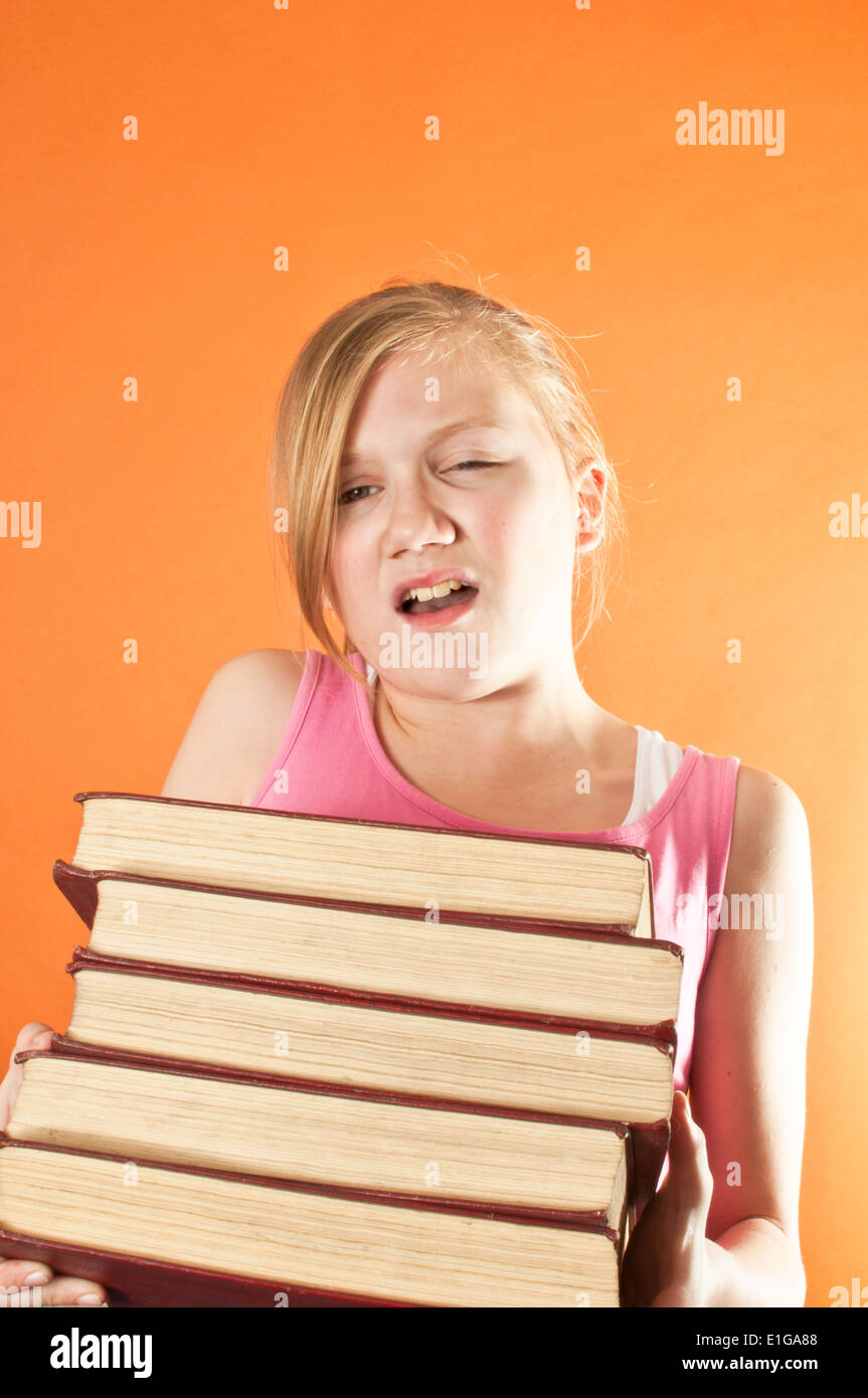 School girl carrying a pile of books Stock Photo - Alamy