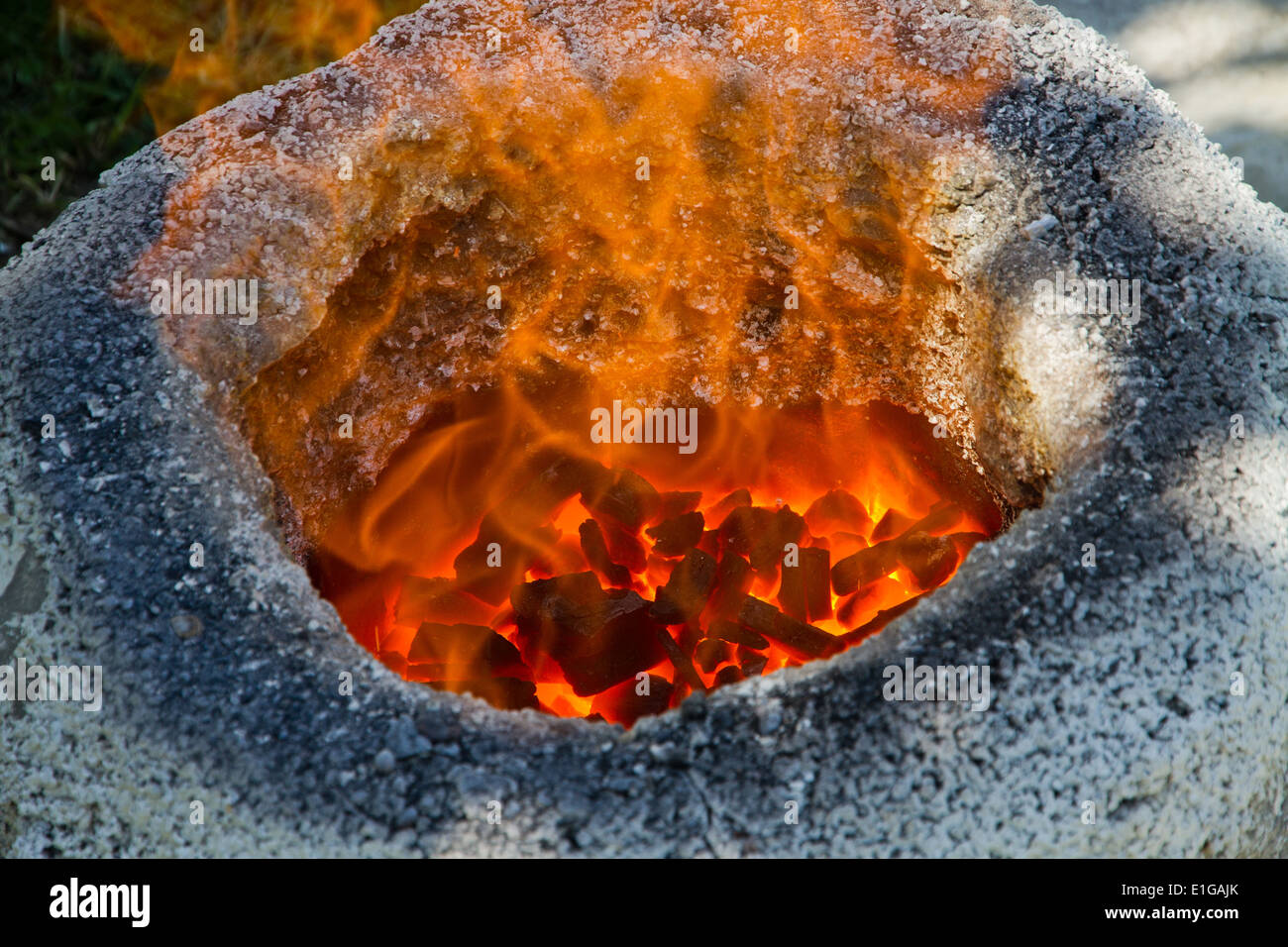 Charcoal burning in a traditional iron smelting furnace Stock Photo