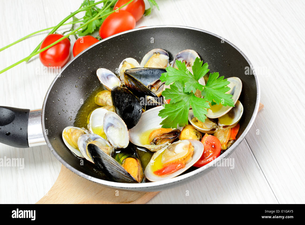 saute seafood in a pan with olive oil and parsley Stock Photo