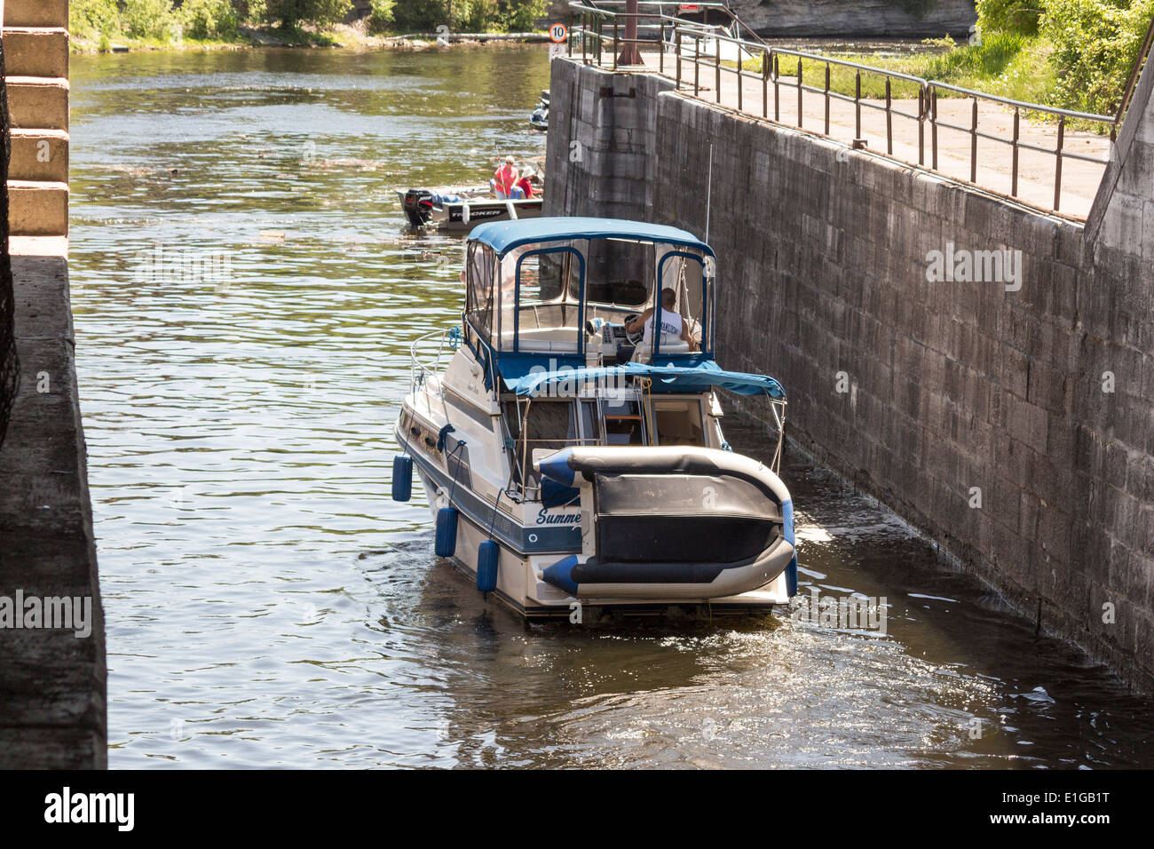 Cabin cruiser heading into Fenelon River after passing through lock 34 on the Trent Severn Waterway Stock Photo