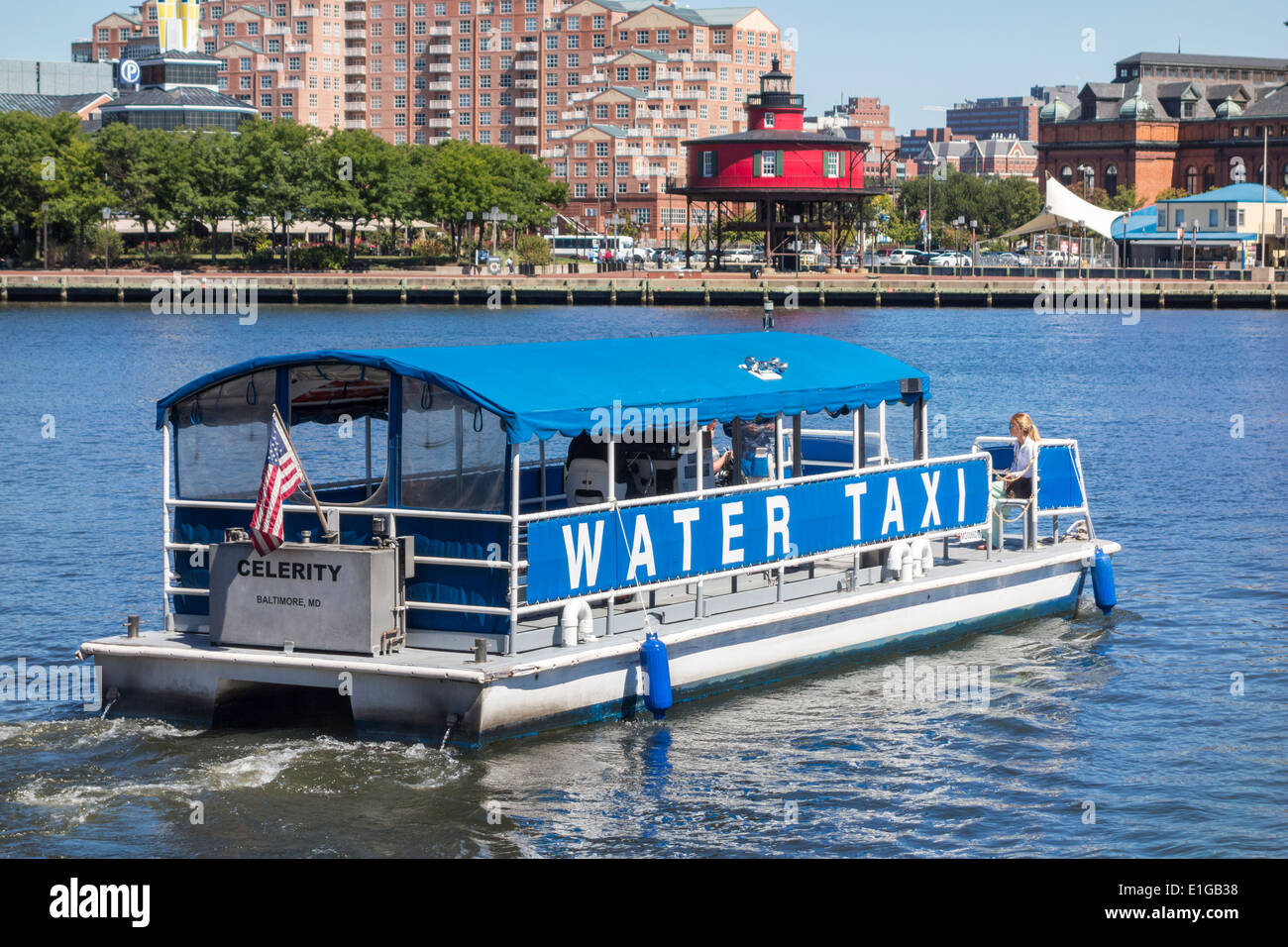Baltimore Water Taxi pontoon boat Celerity and the Seven Foot Knoll Lighthouse part of the Inner Harbor Maritime Museum Stock Photo