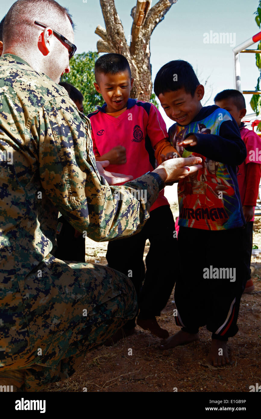 U.S. Marine Corps Alistiar E. Howard, a civil affairs officer with III Marine Expeditionary Force (III MEF), interacts with stu Stock Photo