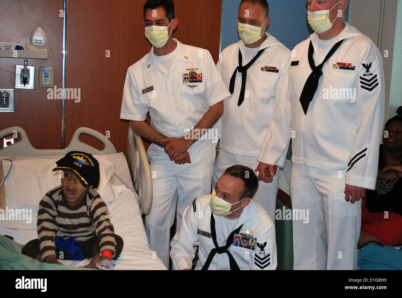 A child in the pediatric ward of the Denver Health and Hospital Authority wears a U.S. Navy ball cap given to him by Sailors fr Stock Photo