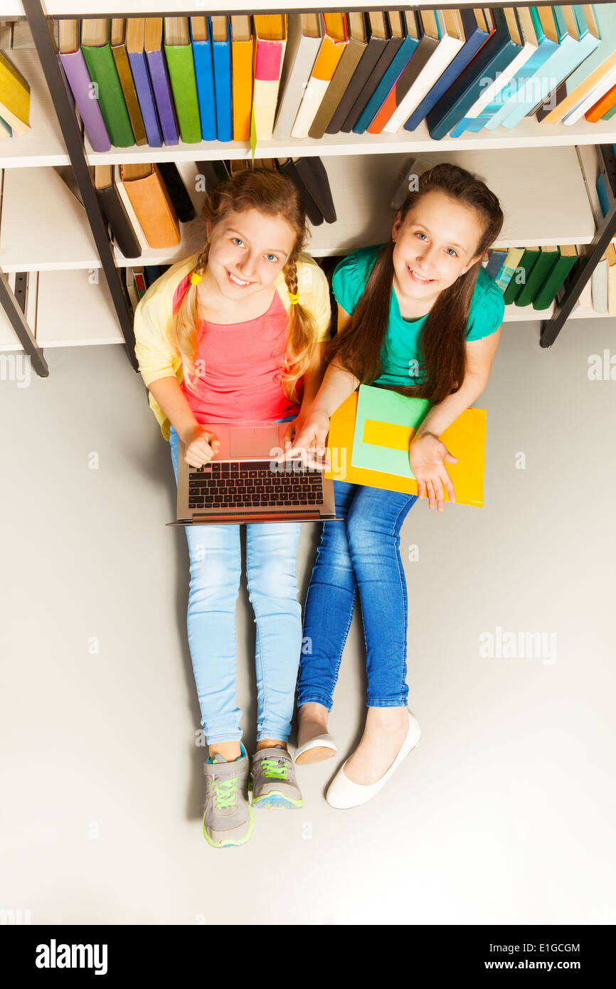 Two happy girls portrait from above sit on floor Stock Photo - Alamy