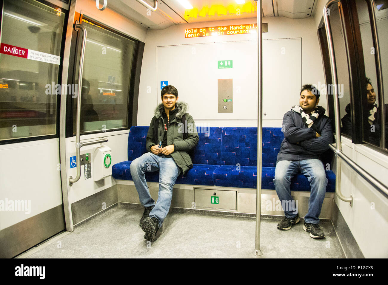 Two guys sitting in Toronto interconnecting airport transit system at Toronto Pearson International Airport Stock Photo