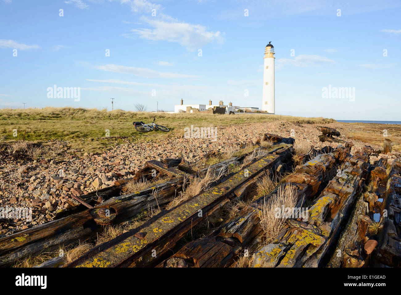 The Barn's Ness lighthouse and remains of an old wreck. Near Dunbar, East Lothian, Scotland. Stock Photo