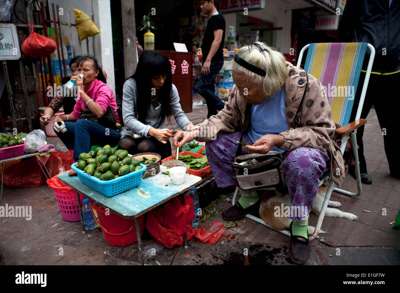 A women selling betel nuts and betel leafs on the street of Sanya, Hainan, China, on 30.12.2013. Betel nut and betel leaf are mild stimulant. Stock Photo