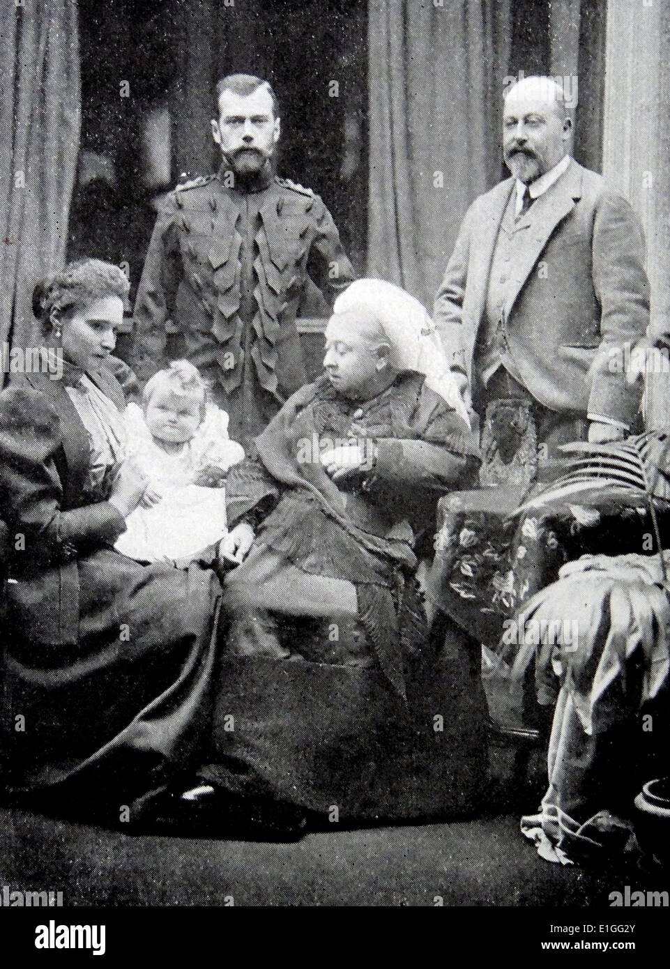 Photograph of Queen Victoria (1819 - 1901) sat in the foreground alongside Tsarina Alexandra Fyodorovna (1872 - 1918) and the infant Grand Duchess Olga Nikolaevna of Russia (1895 - 1918). In the Background is Albert, Prince of Wales (1841-1910) and Tsar Nicholas II (1868 - 1918). Dated 1896 Stock Photo