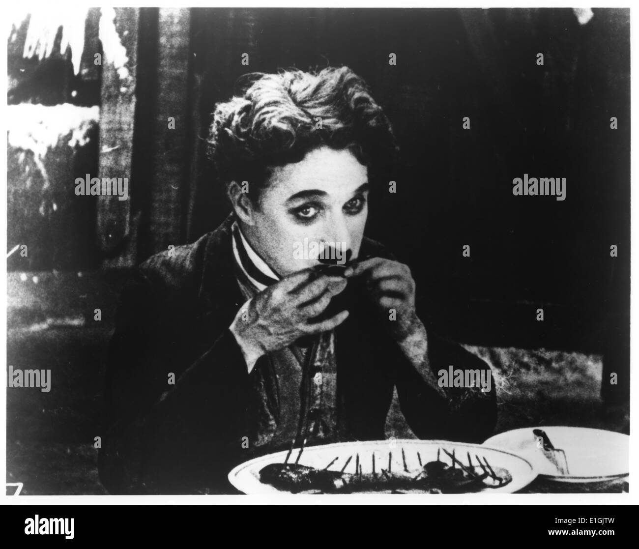 Charlie Chaplin, KBE (1889-1977) The Tramp resorts to eating his boot in a famous scene from The Gold Rush (1925) Stock Photo