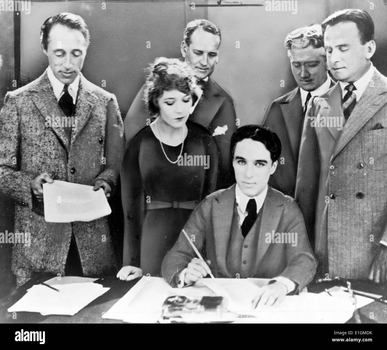 D.W. Griffith, Mary Pickford, Charlie Chaplin (seated) and Douglas Fairbanks at the signing of the contract establishing United Artists motion picture studio Stock Photo