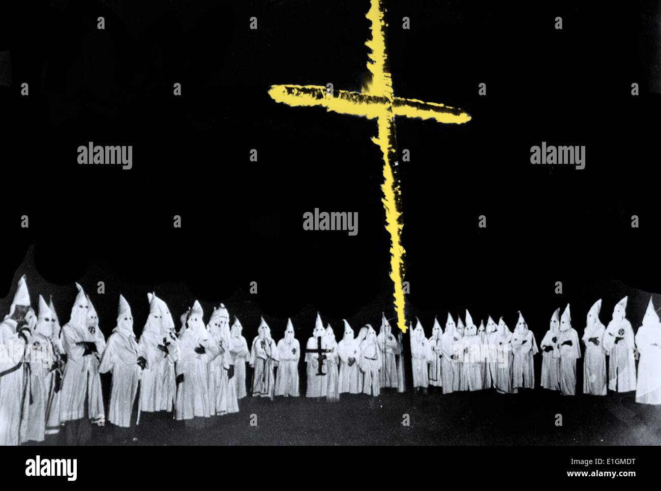 Photograph shows a group of Ku Klux Klan members with cross burning before them. Dated 1948 Stock Photo
