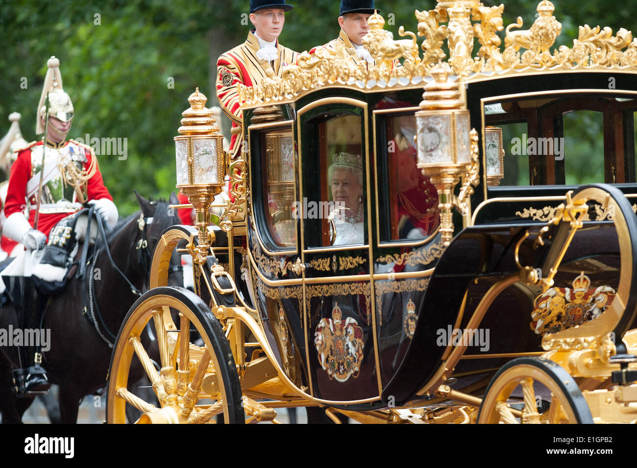 London, UK. 4th June 2014. Queen Elizabeth II is driven through the Mall in Central London in her ceremonial carriage on her way to attend the State Opening of Parliament, on Wednesday June 4, 2014. Credit:  Heloise/Alamy Live News Stock Photo
