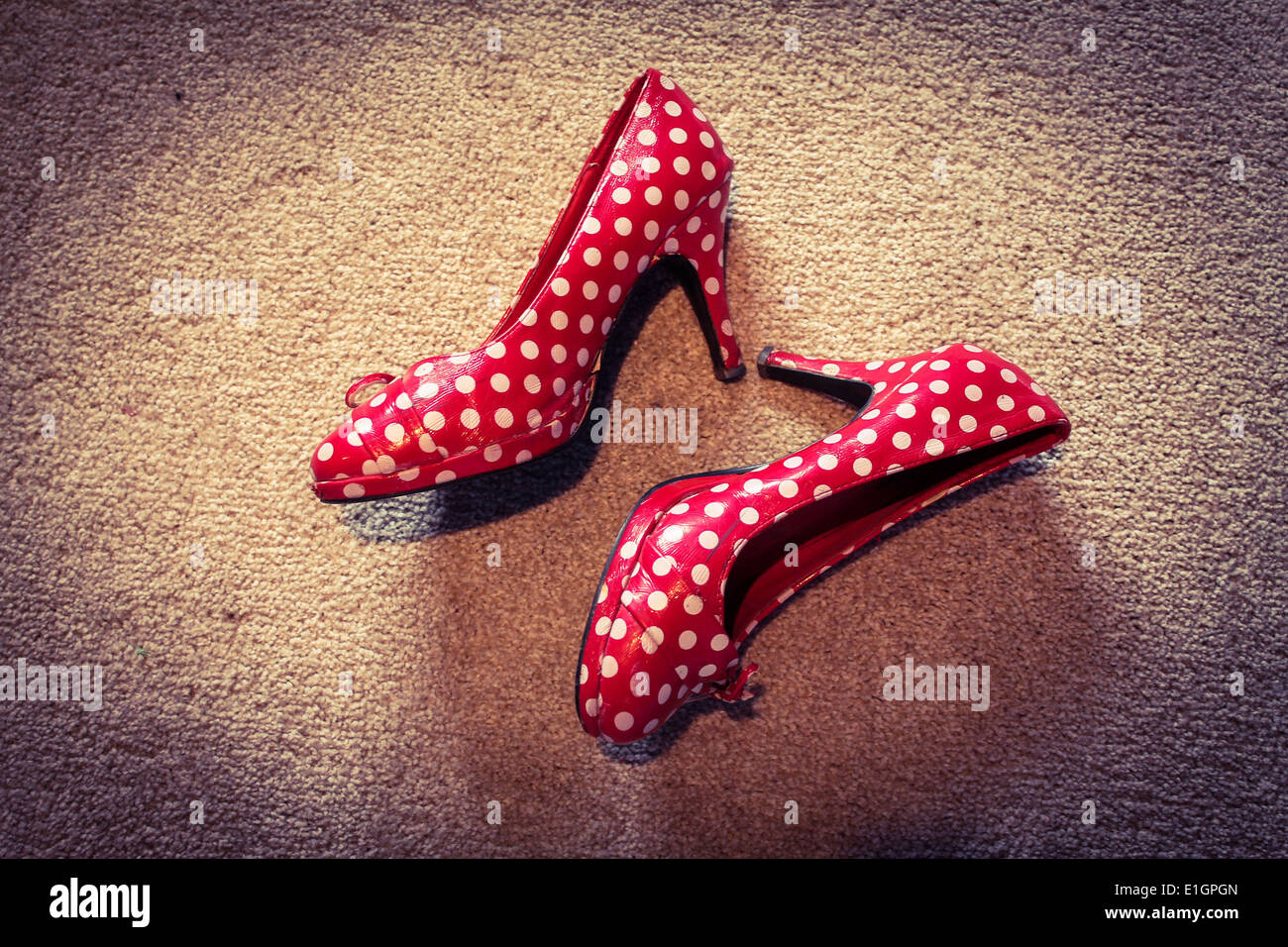 Red polka dot high heel shoes kicked off after a party Stock Photo