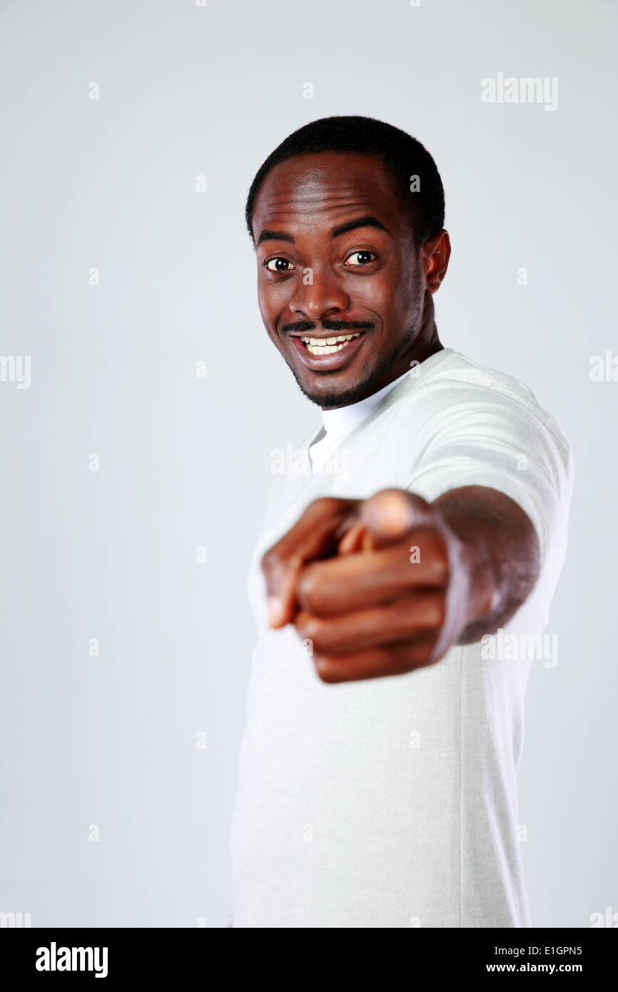 Cheerful african man pointing at you over gray background Stock Photo