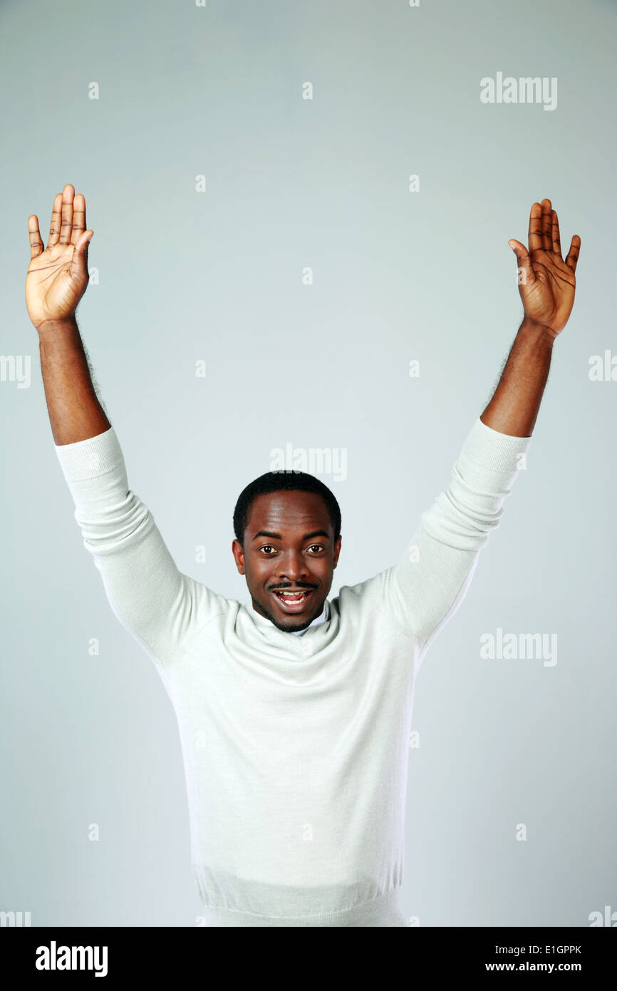 Portrait of african man with raised hands on gray background Stock ...