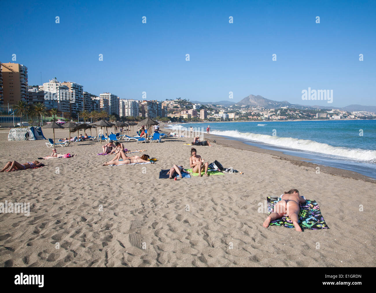 Playa de Malaguera sandy beach people sunbathing by the sea, Malaga