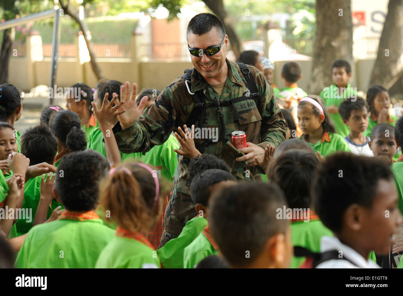 U.S. Navy Lt. j.g. Ron Kolpak, center, interacts with children at the Farol primary school in Dili, Temor-Leste, June 20, 2011, Stock Photo