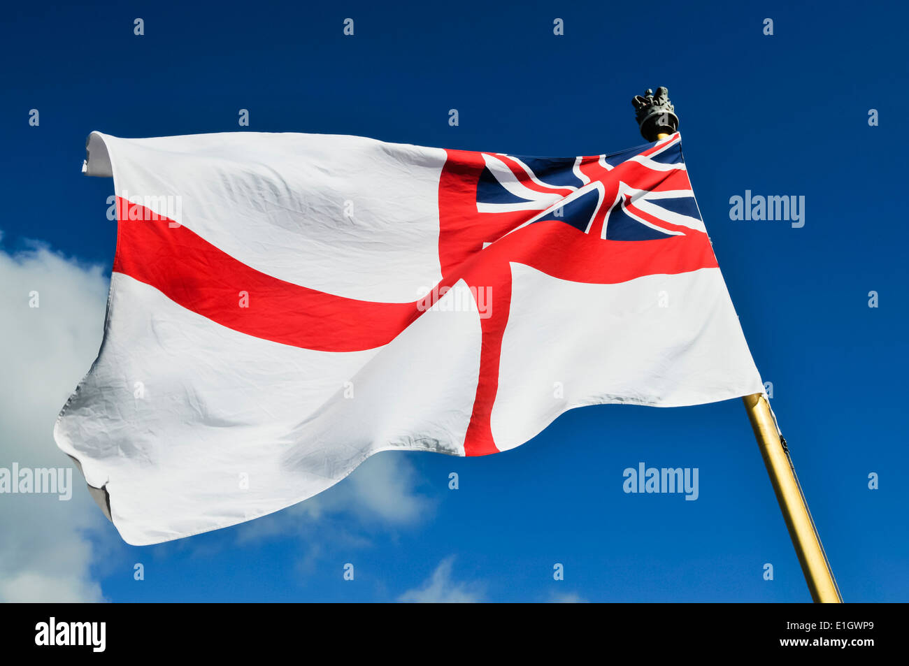 Royal Navy white ensign flying from a warship while docked. Stock Photo