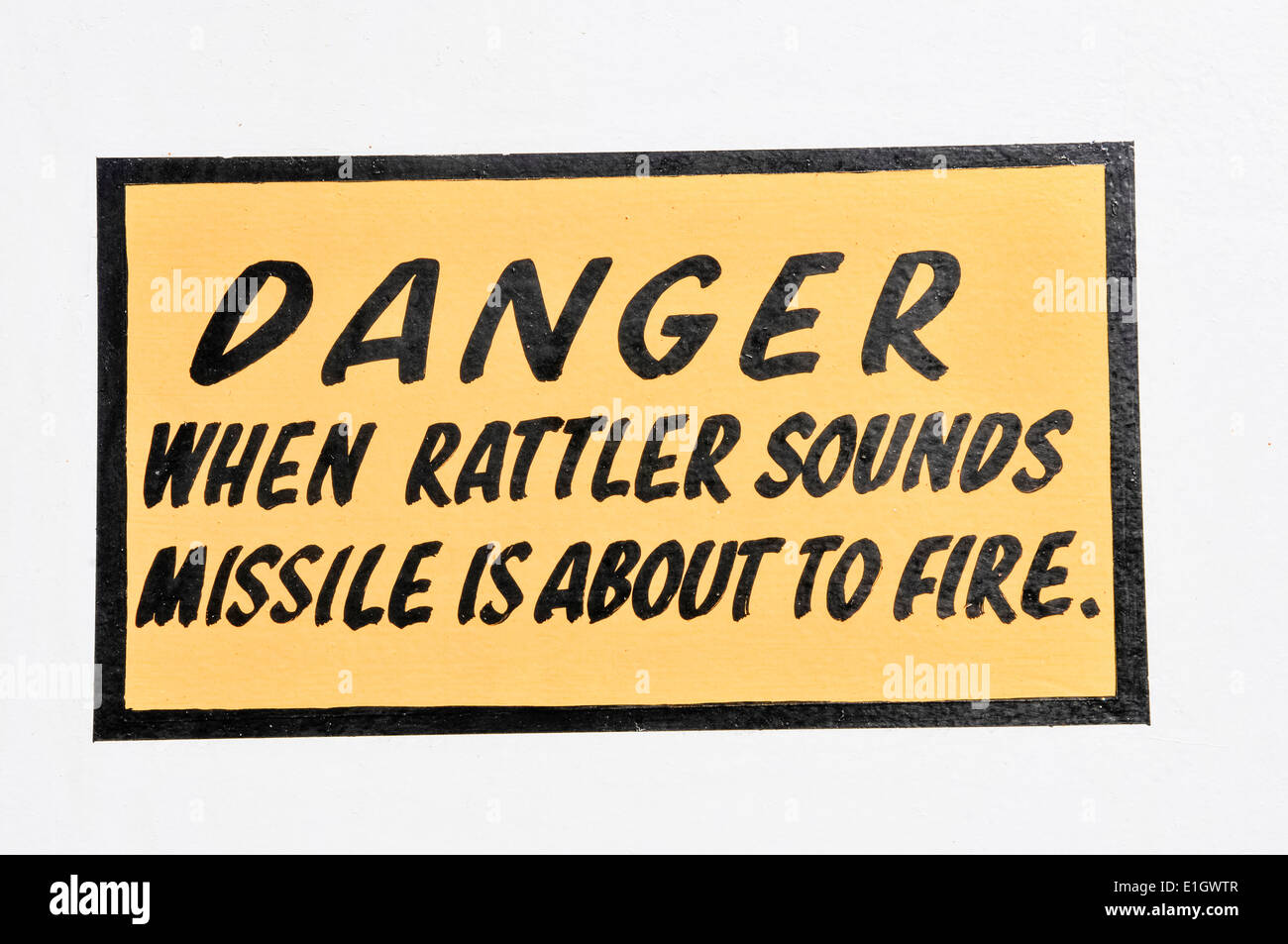 Sign on board a Royal Navy Type 23 frigate, 'Danger - when rattler sounds missile is about to fire' on the Seawolf missile silo Stock Photo