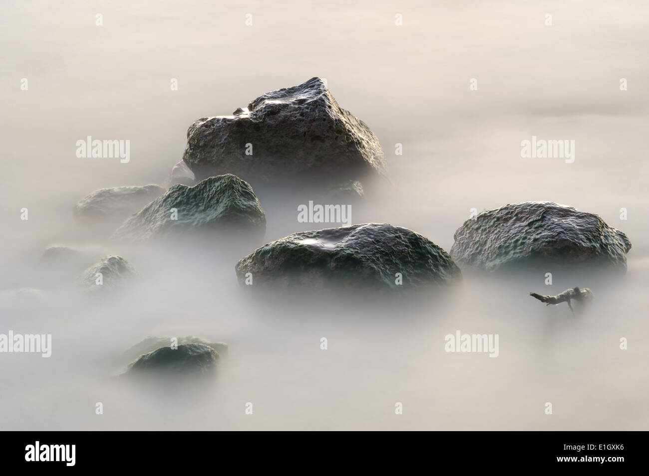 Stones in the lake early morning, wet from the rolling waves. Stock Photo