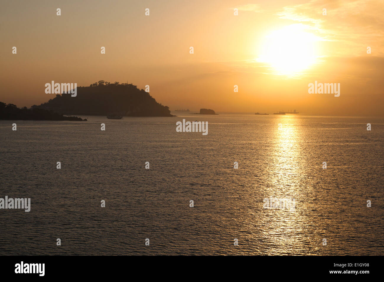 Sunset over the Pacific ocean looking towards Fuerte Amador with cargo ships in the distance, Panama, Central America. Stock Photo